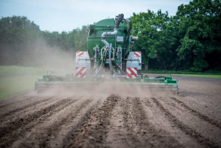 tractor fertilising field farm sludge